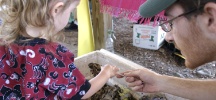 Photo of MC showing worms to child.